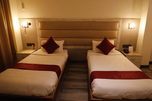 two beds in a hotel room next to each other at The Jamun Tree in Muzaffarpur