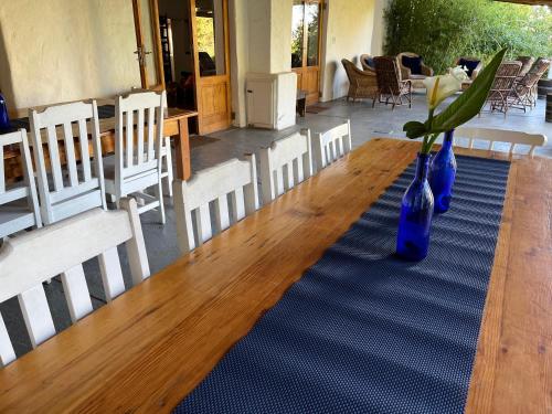 a long wooden table with blue vases on it at Welbedacht Game & Nature Reserve in Tulbagh