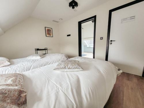 a bedroom with two beds with white sheets at Au bout de mes rêves in Walcourt