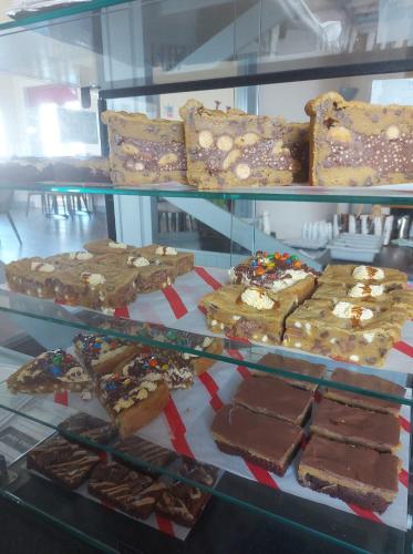 a display case filled with lots of different types of desserts at GOLF View Hotel & Macintosh Restaurant in Lossiemouth