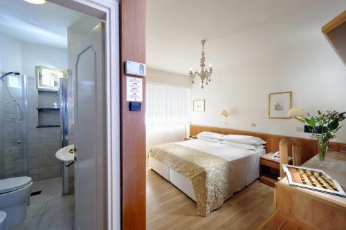 Cette chambre comprend un lit et une salle de bains. dans l'établissement Grand Hotel Playa, à Lignano Sabbiadoro