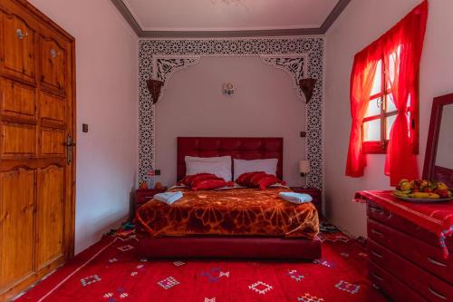 1 dormitorio con 1 cama con edredón rojo en Amazigh Family Riad, en Imlil
