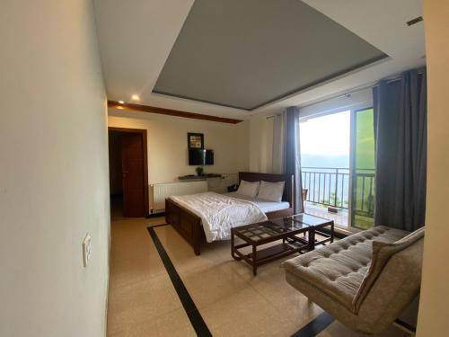 a bedroom with a bed and a couch and a window at AK Hotel & Suites in Murree