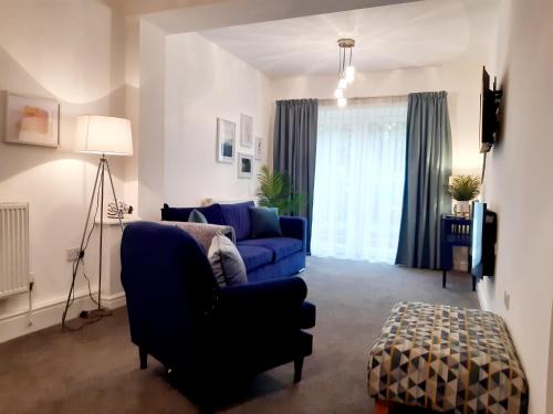 a living room with a blue couch and a blue chair at No's 7 and 8 Llewelyn Apartments in Llanberis