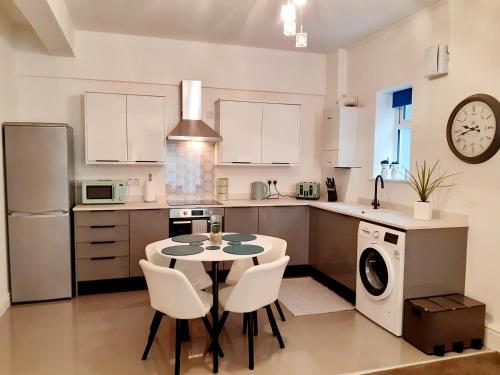 a kitchen with a table and chairs in a kitchen at No's 7 and 8 Llewelyn Apartments in Llanberis