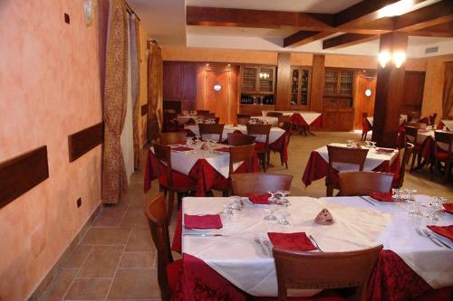 a restaurant with white tables and chairs with red napkins at Agriturismo L'Arca di Anna Brambilla in Belvedere Marittimo