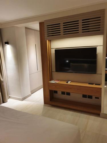 a living room with a large television in a room at Lastarria Hotel in Santiago