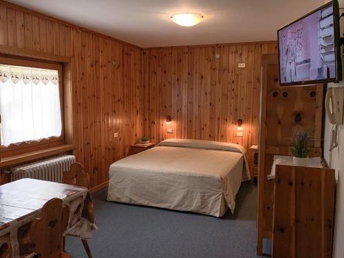 - une chambre avec un lit et une télévision à écran plat dans l'établissement Meublè Sci Sport, à Bormio