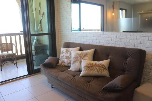 a brown couch with pillows sitting in a living room at Cumbuco - VGSun Apartment 402 in Cumbuco
