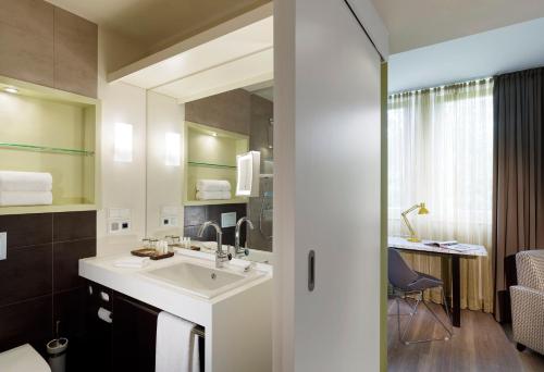 a bathroom with a sink and a mirror at Hotel Indigo - Dusseldorf - Victoriaplatz by IHG in Düsseldorf