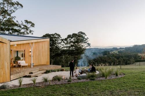 a family standing outside of a tiny house at Upland Farm Luxury Cabins, Denmark Western Australia in Denmark