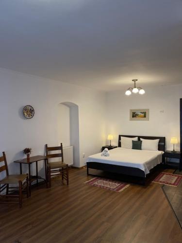 um quarto com uma cama, uma mesa e cadeiras em Pensiunea Central Sibiu em Sibiu