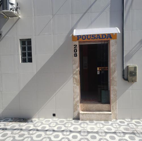 una señal en el lateral de un edificio con una puerta en Pousada Dom Kilmer, en Fortaleza