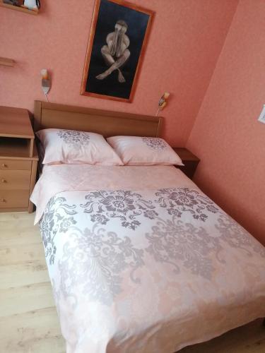 a bedroom with a bed and a picture on the wall at APARTMAJI VALTER in Srpenica