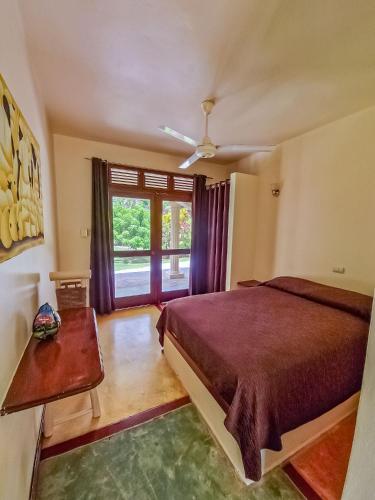 a bedroom with a bed and a large window at Villa La Plantacion in Las Galeras
