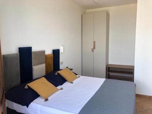 a bedroom with a large bed with two yellow pillows at Casa Miraflores in Cefalù