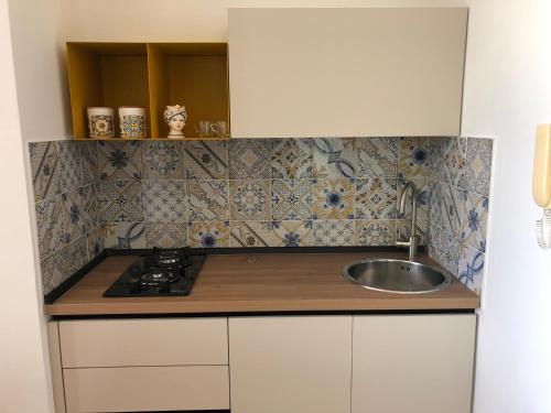 una piccola cucina con lavandino e piano cottura di Casa Miraflores a Cefalù