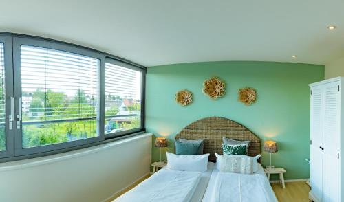 a bedroom with two beds and two windows at Ko´Ono Hotel in Konstanz