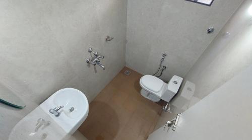 a small bathroom with a toilet and a sink at FOUR SQUARE COMFORTS in Manipal