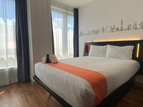 a bedroom with a large bed with a laptop on it at easyHotel Lisbon in Lisbon