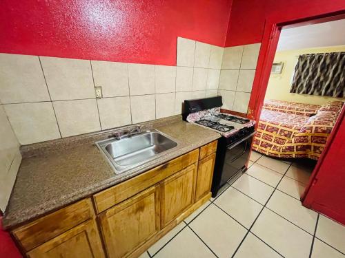 a kitchen with a sink and a stove at Royal Palms Motel in New Orleans