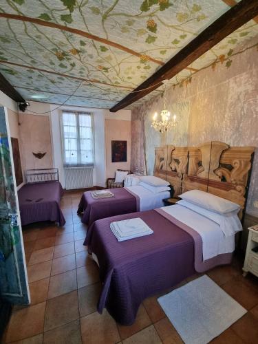 a bedroom with three beds and a ceiling with flowers at La Corte B&B in Ovada