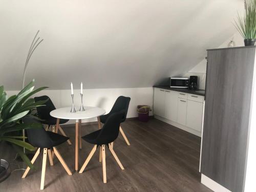 a room with a table and chairs and a kitchen at Zimmervermietung Krug in Eberhardzell