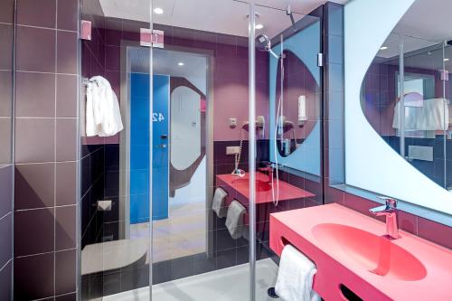 a bathroom with two sinks and two mirrors at prizeotel Vienna-City in Vienna