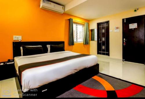 a bedroom with a large bed in an orange room at HOTEL SRIRAMA EMPIRE in Hyderabad
