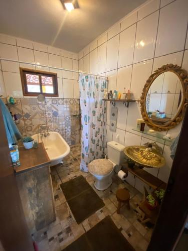a bathroom with a sink and a toilet and a mirror at Casa Abaeté Refúgio Exclusivo com Hot Tub, Vista Serra e Acesso ao Vale do Pati in Mucugê