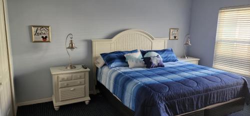 a bedroom with a bed with a blue comforter at My Home in Orlando in Kissimmee