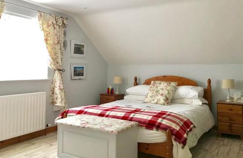 een slaapkamer met een bed met een rode en witte deken bij Ty Croeso in Ballymoney