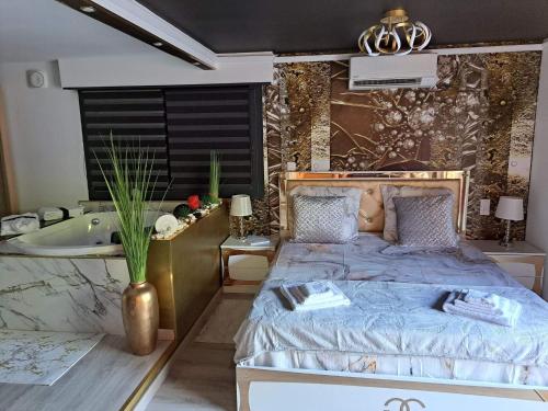 - une chambre avec un lit, une baignoire et un lavabo dans l'établissement L'Aurore suite de charme, clim jacuzzi, sauna, piscine chauffée cuisine..., à Carpentras