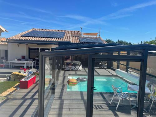 une terrasse avec une piscine et une maison dans l'établissement L'Aurore suite de charme, clim jacuzzi, sauna, piscine chauffée cuisine..., à Carpentras