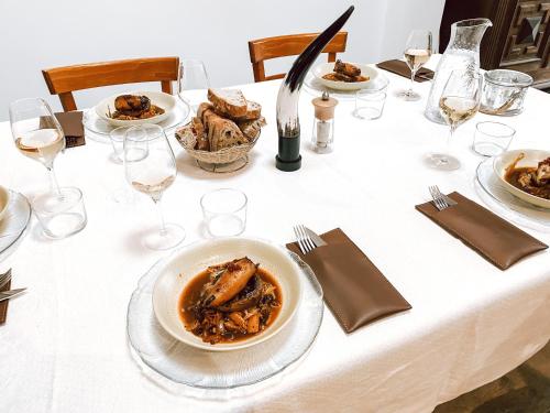 a table with plates of food and glasses of wine at Aux Rives de la Courtade in Rivières