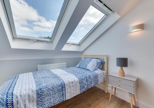 a bedroom with a bed and two skylights at Bryn Triban in Llanddyfnan