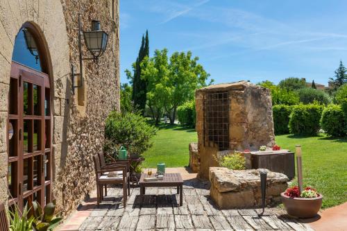 a patio with a table and a stone building at Es Portal Restaurant i Hotel Boutique - Adults only in Pals