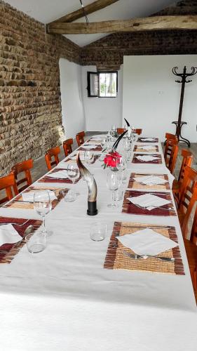 a long table with wine glasses and napkins at Aux Rives de la Courtade in Rivières