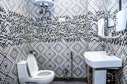 a bathroom with a white toilet and a sink at Click Sunburry Hotel Srinagar in Srinagar