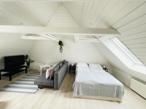 1 dormitorio con 1 cama y 1 sofá en el ático en aday - Charming loft studio, en Aalborg