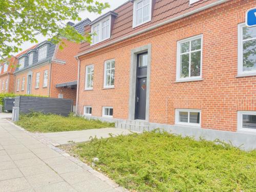 a red brick building with a black door on it at aday - Charming loft studio in Aalborg