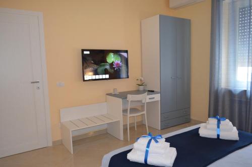 una camera da letto con scrivania e un letto con asciugamani di Raggio di Sole a Gaeta