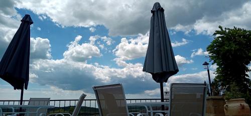 a couple of umbrellas and chairs on a patio at T.H.NY Village Inn Cottage in Tihany