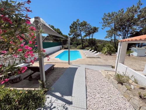 a villa with a swimming pool and a garden at Casa do Moinho de Baixo in Sesimbra