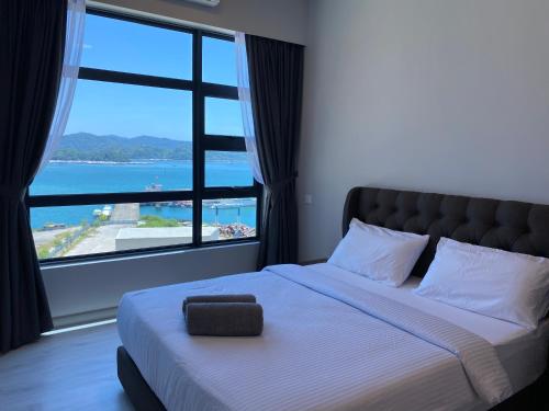 ein Schlafzimmer mit einem großen Bett und einem großen Fenster in der Unterkunft Alawa @ Jesselton Quay Kota Kinabalu in Kota Kinabalu