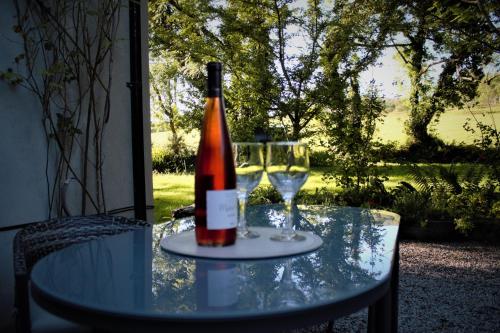 a bottle of wine sitting on a table with two glasses at Remarkable Apartment in Kenmare Ireland in Kenmare