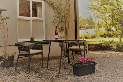 a table with two chairs and a bottle of wine at Remarkable Apartment in Kenmare Ireland in Kenmare