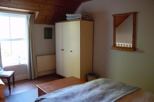 1 dormitorio con cama, espejo y tocador en Remarkable Apartment in Kenmare Ireland, en Kenmare