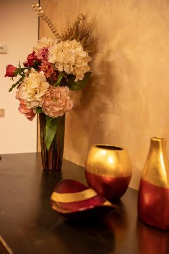 a vase with flowers and a candle on a table at Il Giardino Segreto in Carbognano