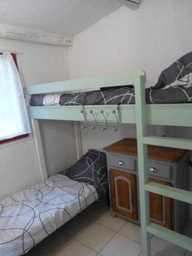 a room with two bunk beds and a desk at 4-Gîte 4 personnes avec piscine in Saint-Aubin-de-Nabirat